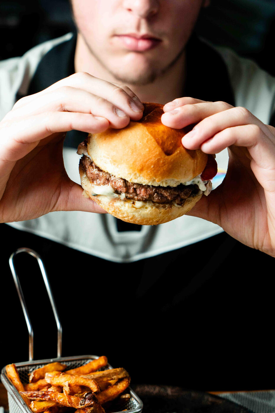homme qui tient un burger