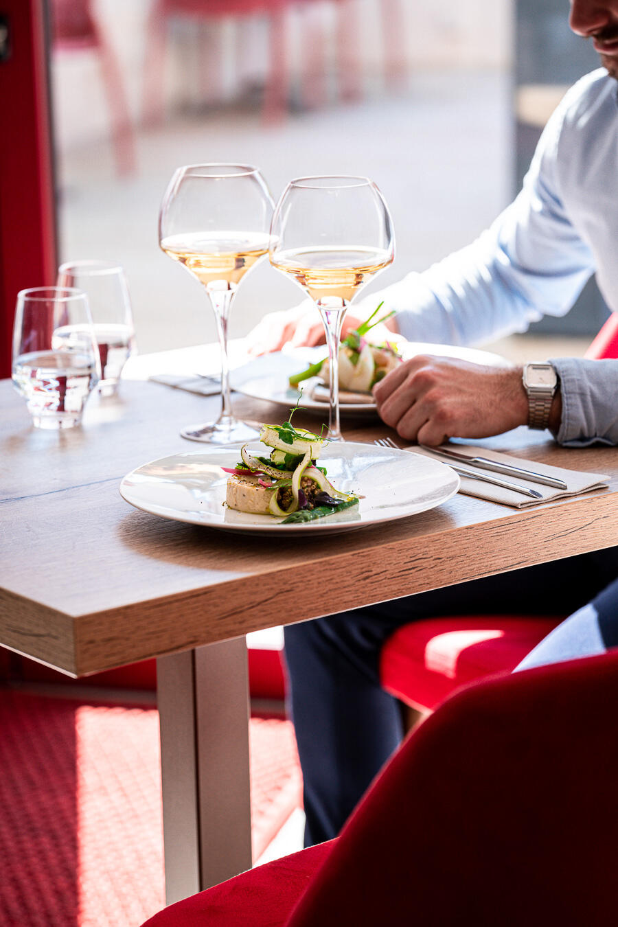 restaurant photographe et vidéaste culinaire à paris homme avec plats et verres de vin blanc