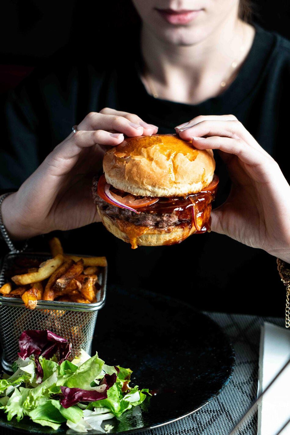 photographe culinaire restaurant paris et région parisienne femme qui tient un burger