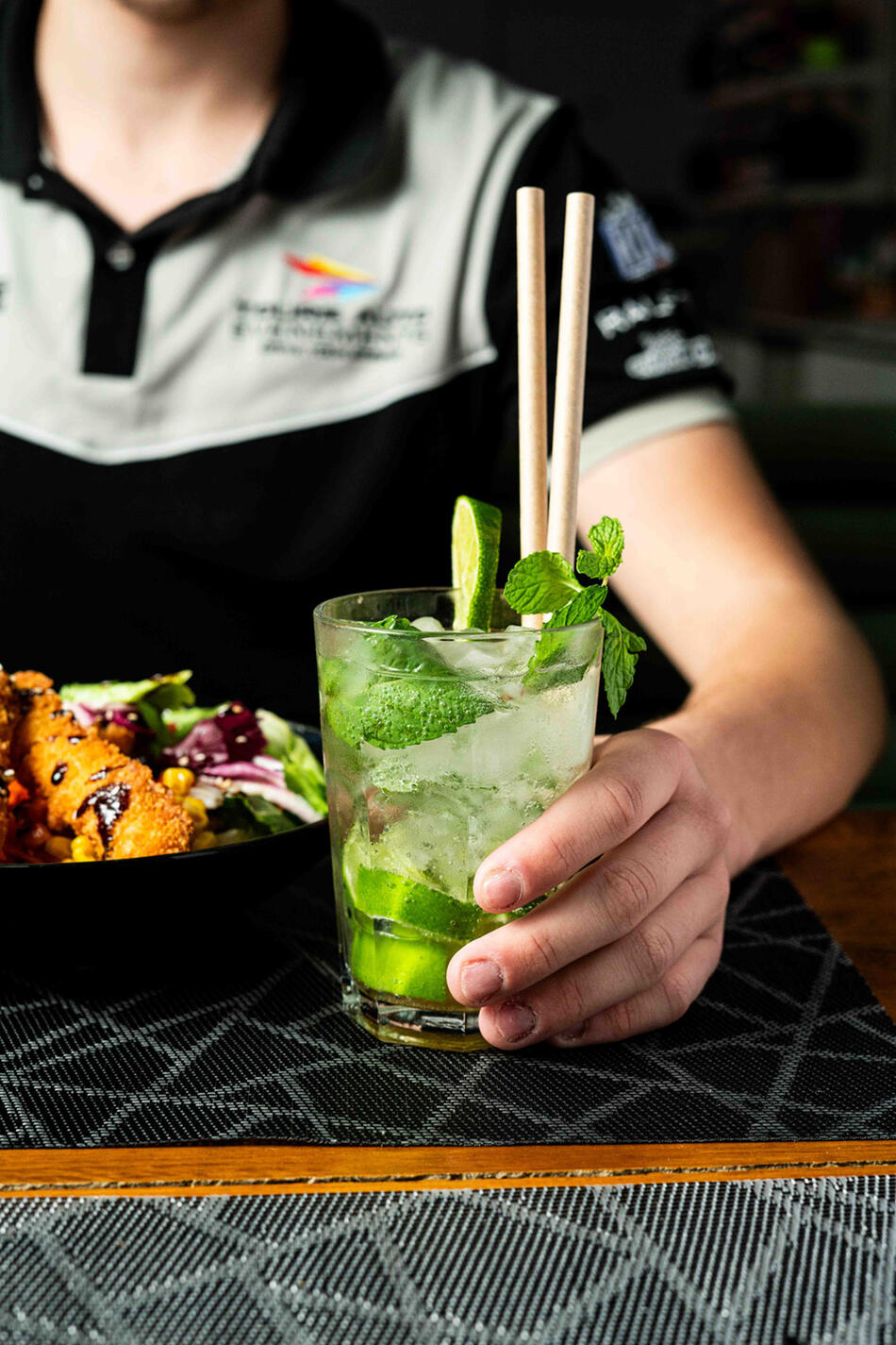 client qui tient son verre de mojito