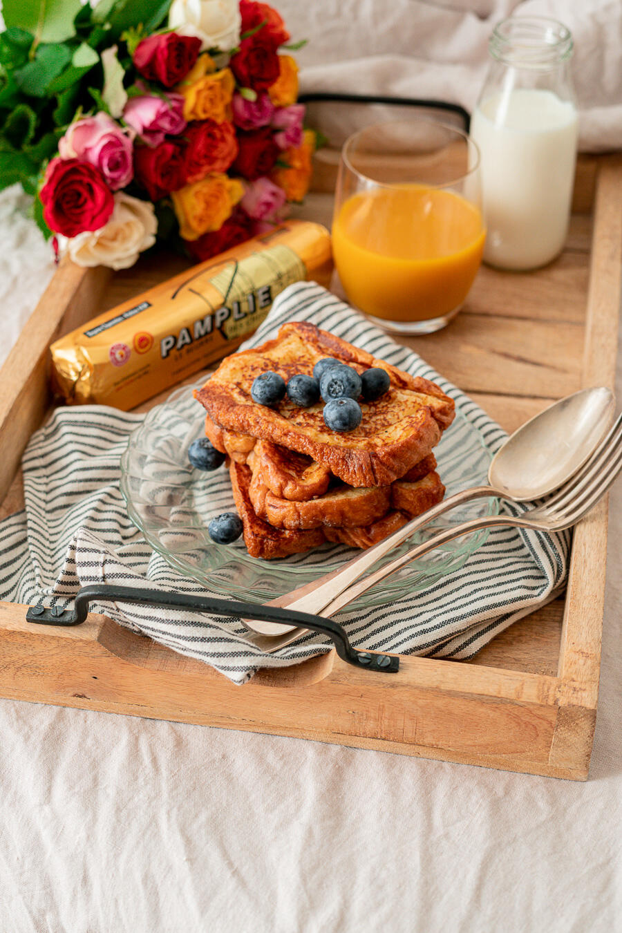 plateau petit déjeuner avec pain perdu, beurre pamplie et jus d'orange