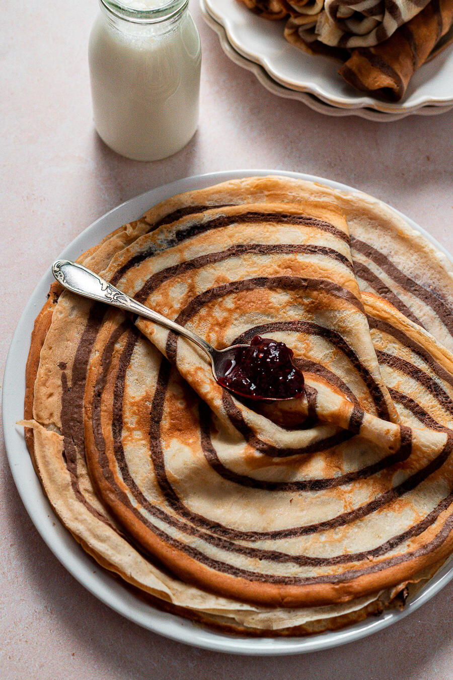 création de recettes photographe et vidéos culinaires assiettes de crêpes avec une cuillere de confiture