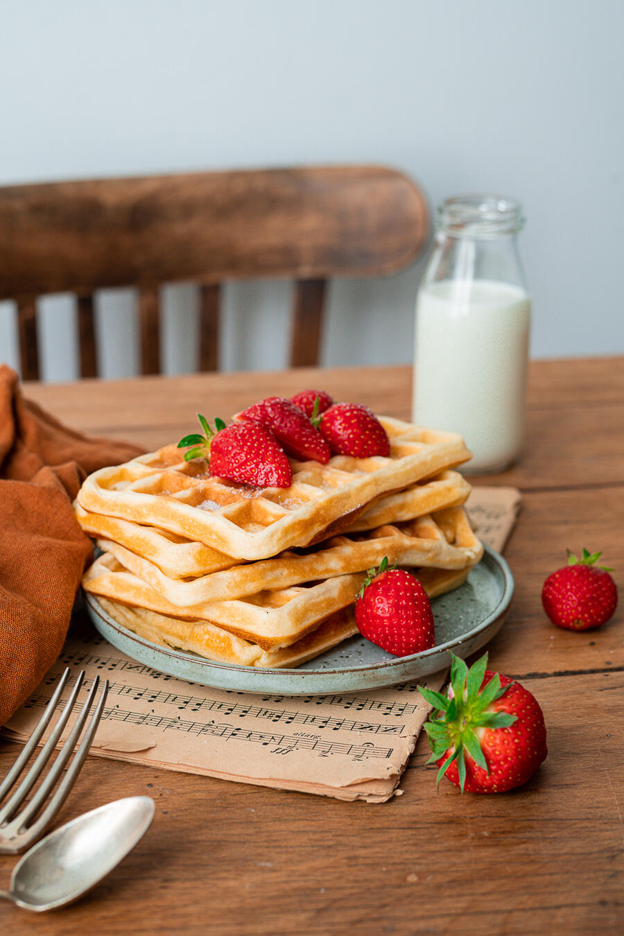 assiettes de gaufres avec des fraises et bouteille de lait